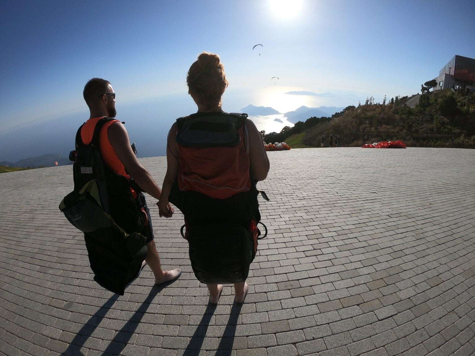 A group of tandem paragliders smiling as they prepare for takeoff