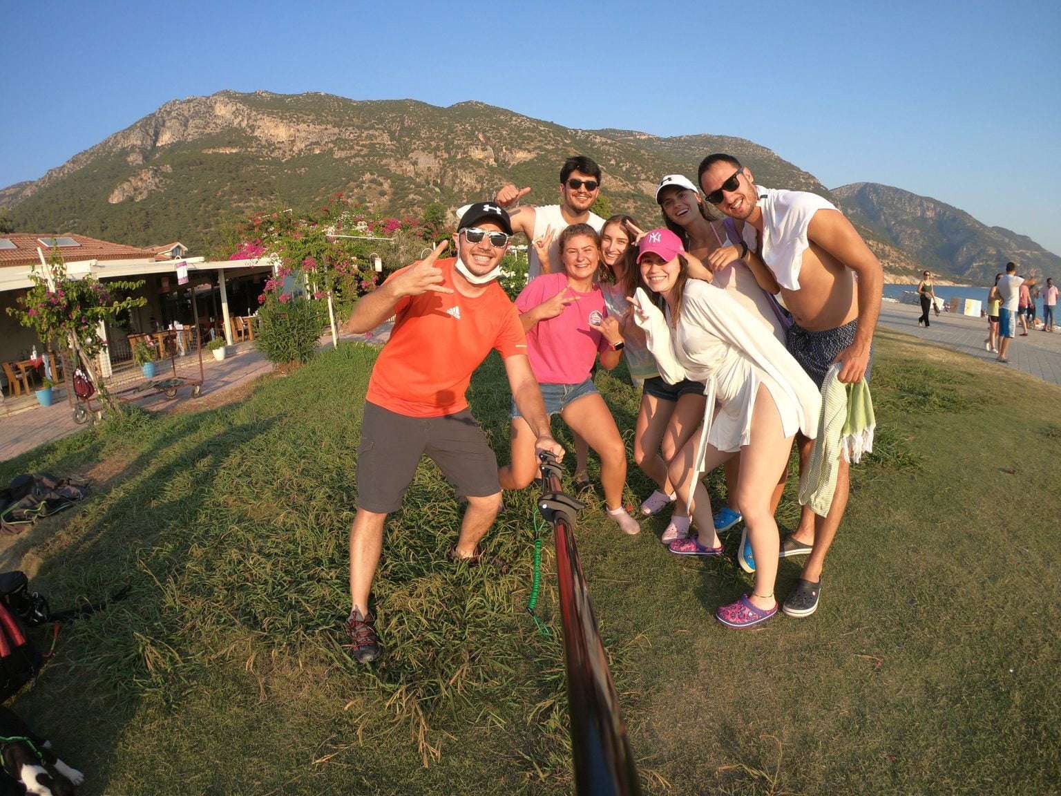 A family watching a tandem paragliding session on the beach